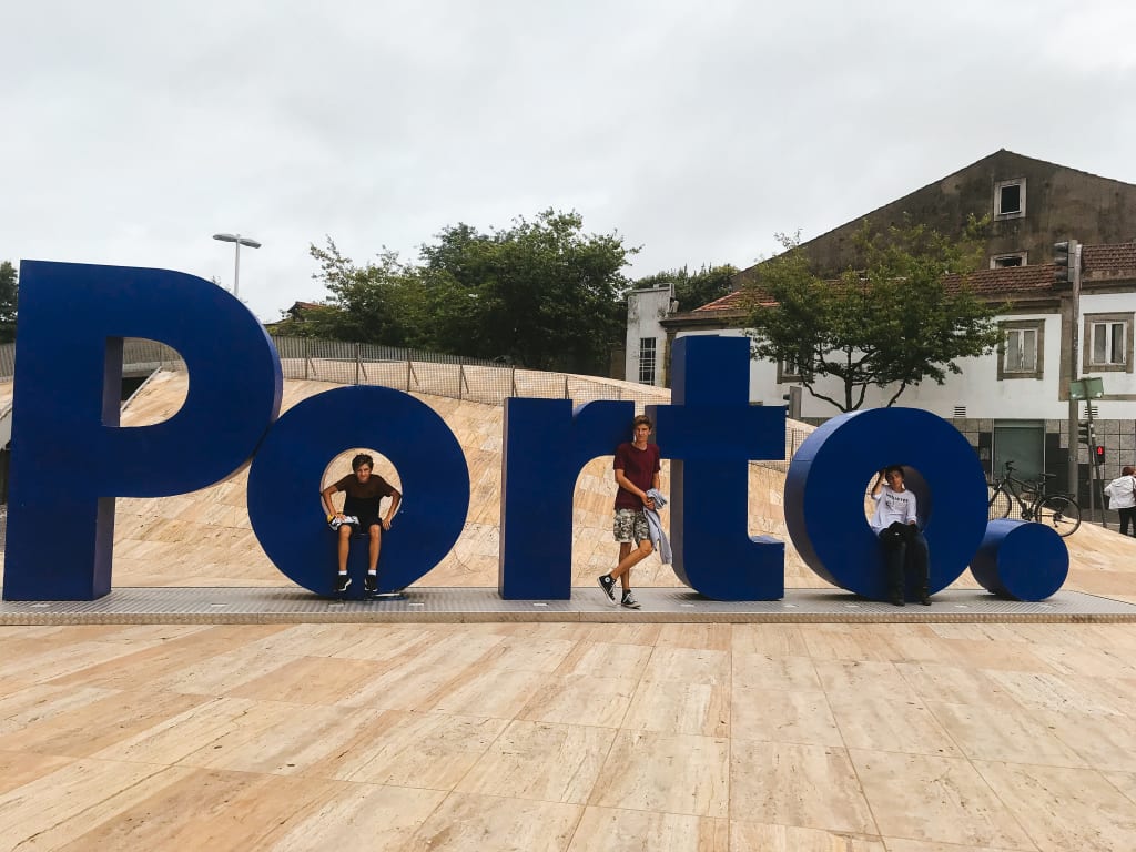 Viaggiatori fanno una foto con un'insegna turistica con la scritta Porto